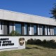 Exterior view of the Travis County Sheriff's Office Forensic Services Division building with a sign and sheriff badge in front.