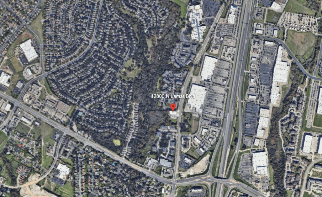Aerial view centered on 12800 N Lamar Blvd, showing roads, office buildings, and surrounding green spaces in a commercial area.