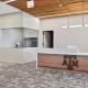 Reception desk with a marble countertop and wooden front displaying 'AM'; beige walls and wood slat ceiling above.